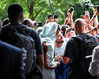 Kylian Mbappé, the captain of France’s men’s football team, signs autographs and poses for selfies with fans outside the team’s World Cup 2026 hotel in Boston, Massachusetts.