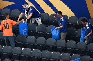 Japan fans put rubbish in blue bin bags after its World Cup against the Netherlands  in Arlington, Texas, on Sunday. Photo: AP