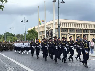 立陶宛民眾在軍儀隊與各城市代表隊伍帶領下，遊行至「佔領與自由鬥爭博物館」旁紀念地點。中央社記者游堯茹維爾紐斯攝　115年6月15日