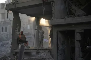 Palestinians clear the rubble of a building that was destroyed in an Israeli airstrike at Al-Maghazi refugee camp in central Gaza Strip on Friday. Photo: AP