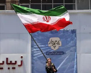 An Iranian woman waves a national flag at Valiasr Square in Tehran.