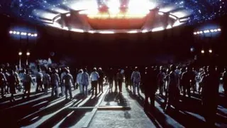A crowd of people walks toward a UFO