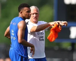 The France men's football captain, Kylian Mbappé (left), talks with the head coach, Didier Deschamps (right), during a training session ahead of their first 2026 World Cup game.
