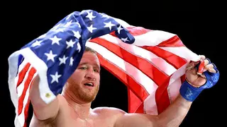 Justin Gaethje celebrates with a US flag after beating Ilia Topuria