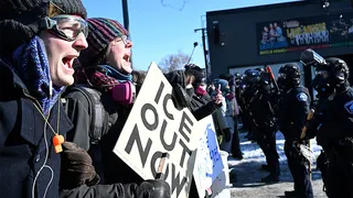Protesters using whistles facing Minneapolis police officers on a city street