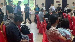 有些信徒坐在椅子上，而有些人，主要是男性，則排隊等待警察帶走。