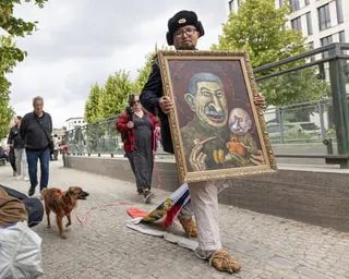 Semyon Skrepetsky holds a caricature of Joseph Stalin and Putin in Berlin