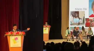 何猷君在台上致辞时，大屏幕惊喜曝光了他儿时就读该校的画面。（互联网）