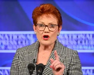 Pauline Hanson gestures while speaking at the National Press Club podium with microphones