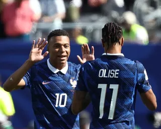 Kylian Mbappé celebrates with Michael Olise after scoring his team's first goal against Senegal.