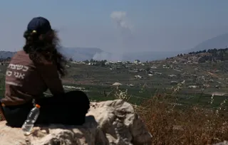 A woman looks at smoke rising in southern Lebanon from the Israeli side of the border on Wednesday. Photo: Reuters