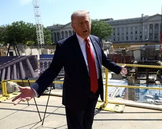 Trump gestures in front of a construction site.