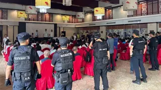 特警隊員包圍了坐在酒店大廳紅色椅子上的信眾。