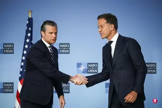 美国战争部长赫格塞斯（左）周四抵达布鲁塞尔北约总部出席北约防长会议时，同北约秘书长吕特握手。 （路透社）