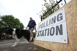 A person at the St Aidan’s Parish Centre polling station with their dog in Wigan, Britain, 18 June 2026.