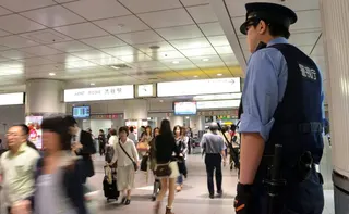 A policeman keeps on eye on commuters at a Tokyo railway station. Photo: AFP