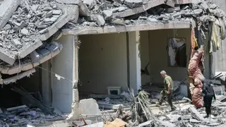 黎巴嫩南部奈拜提耶地区的民众，周四走在被摧毁家园的废墟中。（图取自法新社）