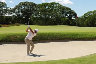 Scottie Scheffler plays his shot from a bunker on the 2nd.
