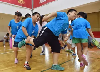 2015年7月16日，在“小壮壮”暑期训练营，学生正在进行趣味训练。（图取自新华社）