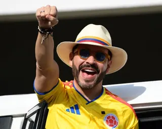 Abelardo de la Espriella in a Colombia football shirt and panama hat, raising his fist