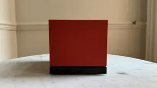 Steam Machine photograph showing the steam machine with red faceplate on a marble circular table in front of a grey/beige wall