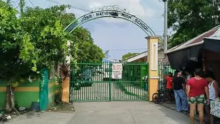 菲律宾莱特省塔克洛班市圣何塞国立高中周一发生枪击事件后，人们聚集在学校大门旁。（图取自法新社）