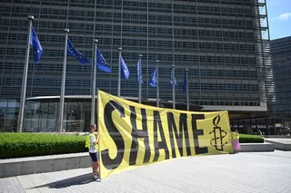 Amnesty International activists hold a banner reading "Shame" in front the EU Commission headquarters to protest against a meeting with a Taliban delegation in Brussels on June 23, 2026.