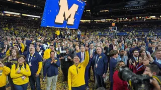 Michigan head coach Dusty May celebrating on the basketball court.