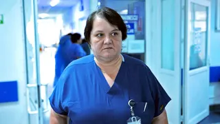 Surgeon Dr Oana Goidescu on shift at Buzău Hospital in blue scrubs. She has mid length black hair