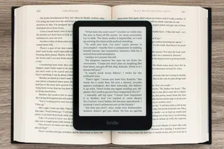 The Amazon Kindle Paperwhite Signature Edition (2024) displaying a page of text sitting on an open book.