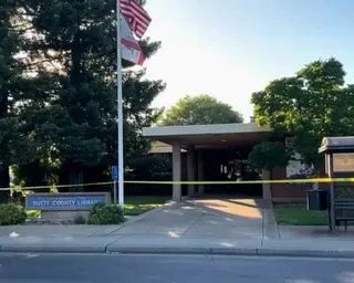 yellow crime scene tape in front of a library
