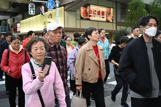Members of a Chinese tour group cross a road in Tokyo on November 17, 2025. Analysts warn that a potential drop in Chinese tourists to Japan due to rising visa fees could economically squeeze Japanese local governments. Photo: AFP