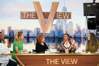 Five women sit at a table and talk during recording of an episode of The View.