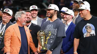 Jalen Brunson holding NBA Finals MVP trophy celebrating with New York Knicks owner James Dolan