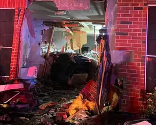 A Tesla crashed through a brick wall into a Katy home, surrounded by debris and emergency lighting