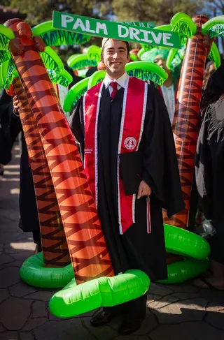 Harry Kaplan with his inflatable palm tree and a sign on his head that says PALM DRIVE