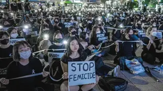 在2022年首爾的一場抗議活動中，一名女子高舉寫著「停止女性殺害（stop femicide）」的標語。