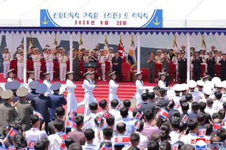 North Korean leader Kim Jong Un attends a naval commissioning ceremony, with military officials nearby.