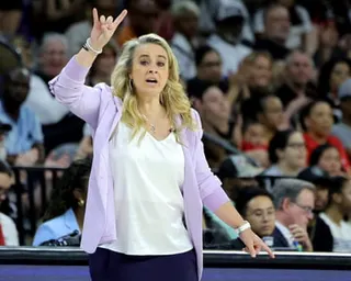Head coach Becky Hammon gestures with her hand raised while coaching from the sideline