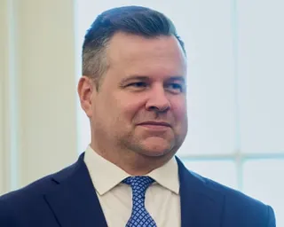 person wearing navy suit and patterned blue tie