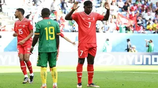 Breel Embolo of Switzerland, wearing a red shirt with the number seven on it, raises his arms after scoring against Cameroon, his country of birth, in the 2022 World Cup