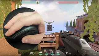 The Valorant practice range with a superimposed image of a hand on a Zowie EC2-DW gaming mouse.