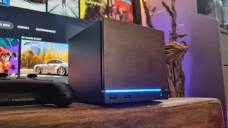 A Steam machine sitting in front of a TV.