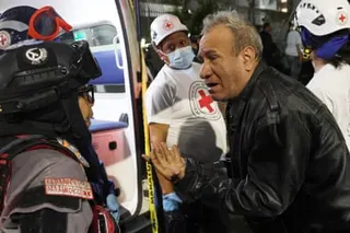 A worried-looking man speaks to a paramedic in Los Palos Grandes.