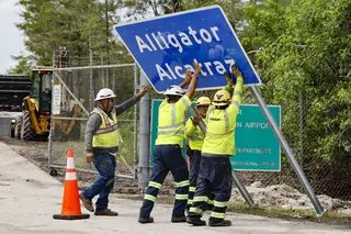 Workers install a permanent “Alligator Alcatraz” sign in Collier County, Florida, in July 2025. Photo: TNS