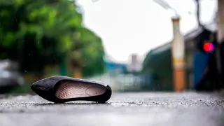 The right side par of a black school shoe lays on the payment after the Tacloban high school mass shooting in the Philippines