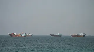 Four large boats drifting on the Strait of Hormuz as seen from Oman.