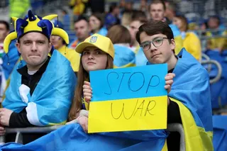 Ukraine fan holds a sign in support of Ukraine amid Russia's invasion at a World Cup qualifier against Wales in 2022