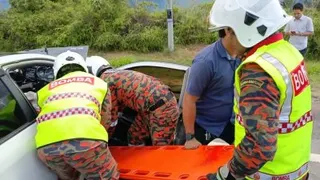 消拯员将死者遗体移出车外后，交由警方接手处理。（图由消拯局提供）