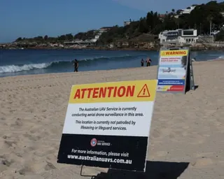 A sign notifying the public of shark-drone surveillance operating in the area at Coogee beach in Sydney on 16 June.